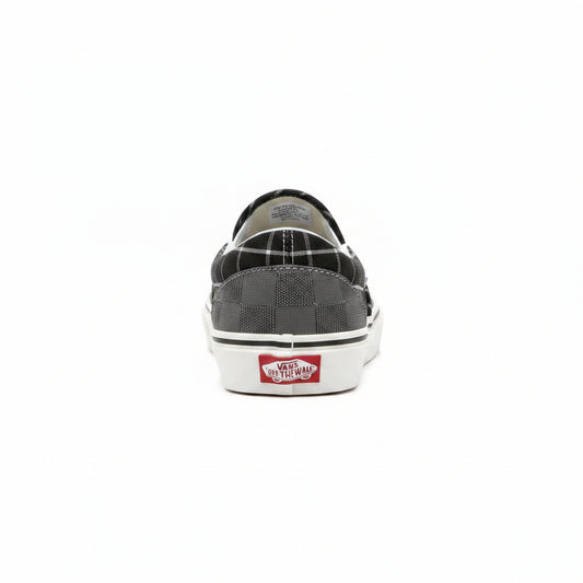 Grey Vans Classic Slip-On sneakers by Raw Movement with canvas upper and rubber sole, positioned on a flat surface.
